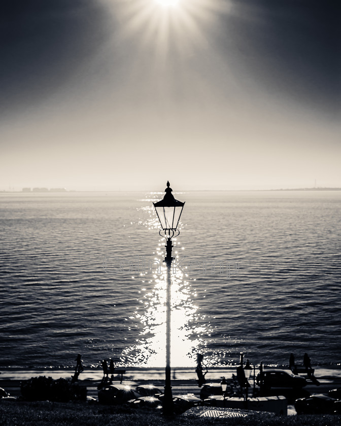 Lamp-post-silhouette-against-sea-1CK 6532-E3 
 A Victorian style lamp post, silhouetted against a sea brightly illuminated by low winter sun. Taken at Westcliff on Sea, near Southend in Essex, UK. Mono fine art photo, with just a hint of split toning. Alternate crops and sizes available. 
 Keywords: Southend, Westcliff. mono, coastal, lamp post, seafront, fine art black and white, victorian lamp post,